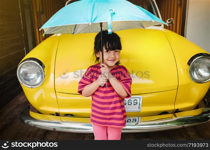 Portrait of Happy Kids with an Umbrella before Outing. Protecting Rain or Sunlight in Summer or Rainy Season Concept. Cute 3-4 Years Old Girl in Happiness Moment.Looking at Camera