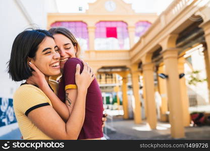 Portrait of happy lesbian couple spending time together and hugging at the street. LGBT., love and relationship concept.