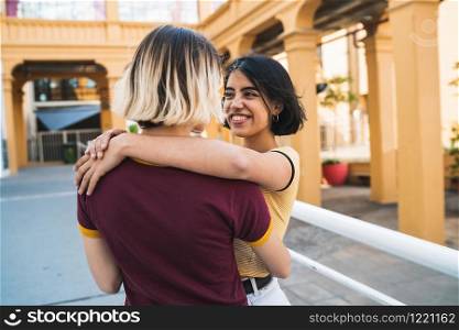Portrait of happy lesbian couple spending time together and hugging at the street. LGBT concept.