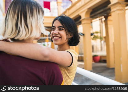 Portrait of happy lesbian couple spending time together and hugging at the street. LGBT concept.