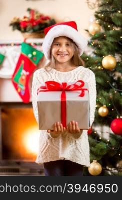 Portrait of happy little girl holding big Christmas gift box