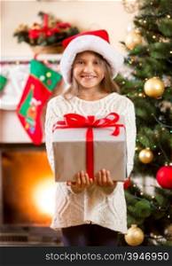 Portrait of happy little girl holding big Christmas gift box