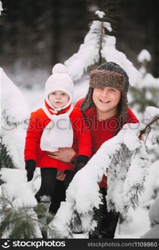 Portrait of happy little girl in red coat with dad having fun with snow in winter forest. girl playing with dad.. Portrait of happy little girl in red coat with dad having fun with snow in winter forest. girl playing with dad