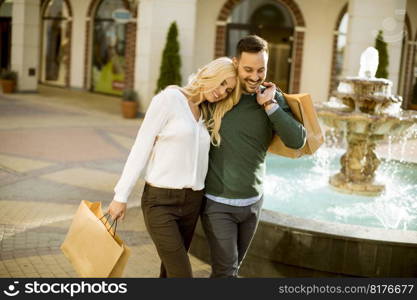 Portrait of happy loving couple with shopping bags and enjoying together