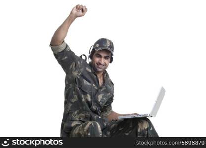 Portrait of happy man celebrating success while using laptop