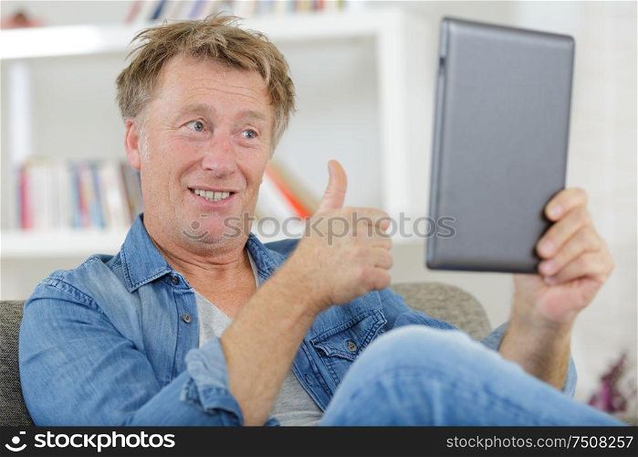 portrait of happy man waving to a friend online