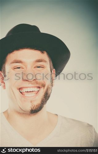 Portrait of happy man with half shaved face beard hair in hat. Smiling handsome guy on blue. Skin care hygiene and fashion. Instagram cross filter.. Happy man with half shaved face beard hair in hat.