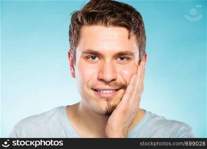 Portrait of happy man with half shaved face beard hair. Smiling handsome guy on blue. Skin care and hygiene.. Happy man with half shaved face beard hair.