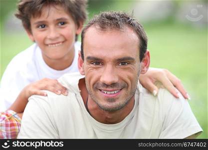 Portrait of happy man with little boy outdoors,