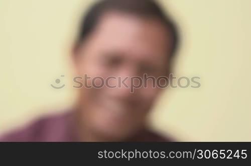 Portrait of happy mature Asian man smiling and looking at camera