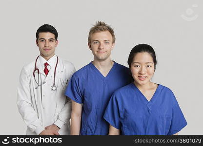 Portrait of happy medical team standing over gray background