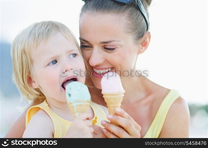 Portrait of happy mother and baby eating ice cream