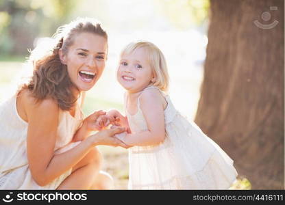 Portrait of happy mother and baby in park