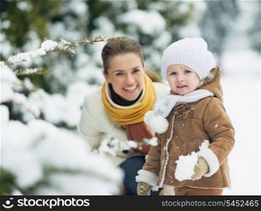 Portrait of happy mother and baby in winter park