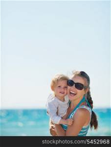Portrait of happy mother and baby on beach