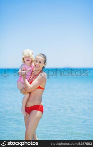Portrait of happy mother and baby on sea background