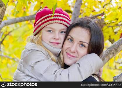 Portrait of happy mother and daughter in autumn