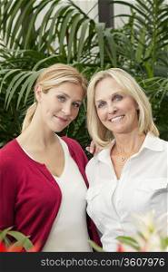Portrait of happy mother and daughter in greenhouse