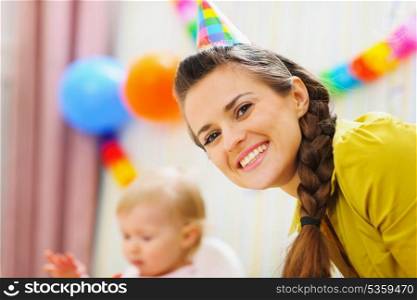Portrait of happy mother at babies birthday party