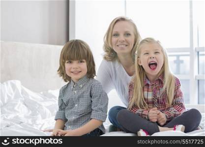 Portrait of happy mother with children in bedroom