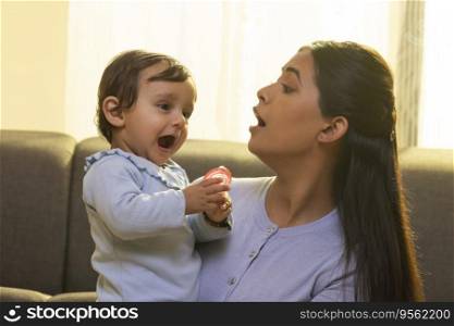 Portrait of happy mother with her and little baby at home