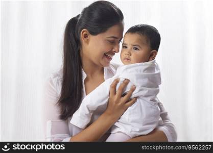 Portrait of happy mother with her little baby at home