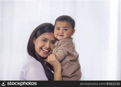 Portrait of happy mother with little baby at home
