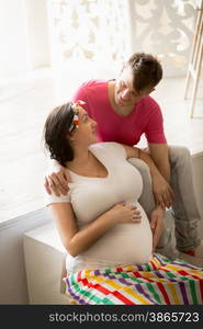 Portrait of happy pregnant woman and husband looking at each other