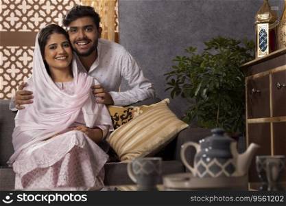 Portrait of happy romantic Muslim couple in living room