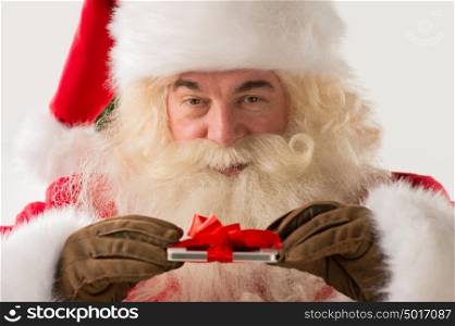 Portrait of happy Santa Claus holding gift device in his hands with ribbon