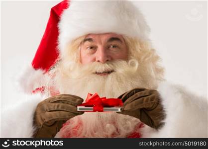 Portrait of happy Santa Claus holding gift device in his hands with ribbon