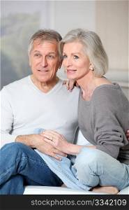 Portrait of happy senior couple sitting in sofa