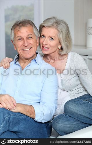 Portrait of happy senior couple sitting in sofa