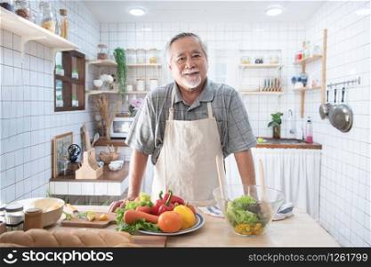Portrait of happy senior elderly asian grandfather standing cooking meal in kitchen,Old men prepare dinner in hobby lifestyle.