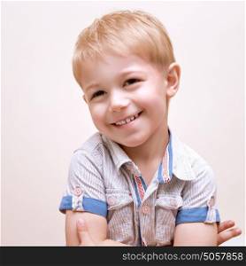 Portrait of happy smiling boy isolated on beige background, studio shot, adorable preschooler, cheerful facial expression, fun and happiness concept
