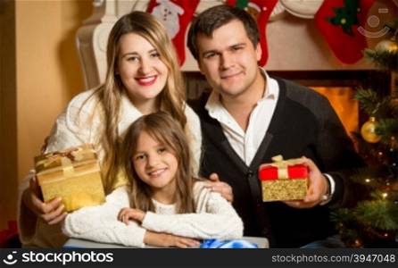 Portrait of happy smiling family posing at fireplace at Christmas