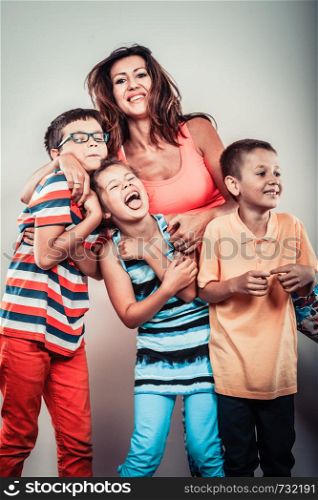 Portrait of happy smiling family sweet cute kids little girl, boys and mother woman in studio. Childhood happiness.. Happy smiling family kids little girl and boys.