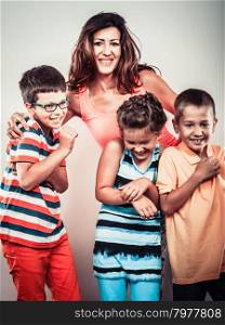 Portrait of happy smiling family sweet cute kids little girl, boys and mother woman in studio. Childhood happiness.