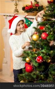 Portrait of happy smiling girl decorating Christmas tree