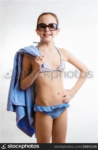 Portrait of happy smiling girl in sunglasses holding beach towel