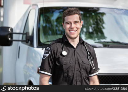 Portrait of happy smiling man paramedic in front of ambulance