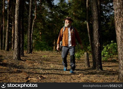 Portrait of happy smiling mature man tourist with Scandinavian sticks spending day outdoors enjoying hiking activity. Happy smiling mature man spending day outdoors enjoying hiking