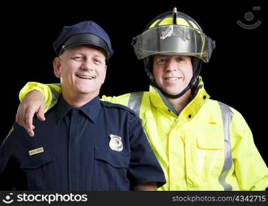 Portrait of happy, smiling police officer and fire fighter on black background.