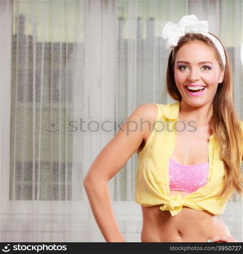 Portrait of happy smiling pretty pin up girl with hairband bow. Attractive gorgeous young retro woman posing.