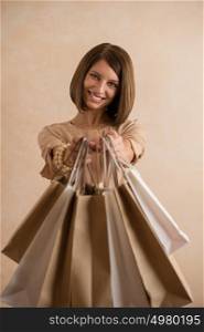 Portrait of happy smiling woman holding shopping bags sharing it to camera