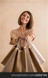 Portrait of happy smiling woman holding shopping bags sharing it to camera