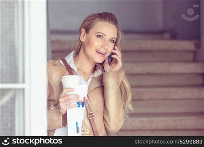 Portrait of happy smiling woman with pleasure talking on the phone, communicating with someone on coffee break, modern life of successful young people