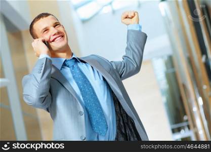 Portrait of happy smiling young businessman, standing in office