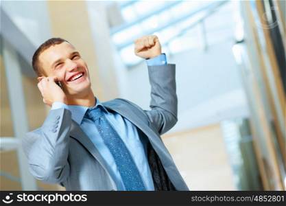Portrait of happy smiling young businessman, standing in office