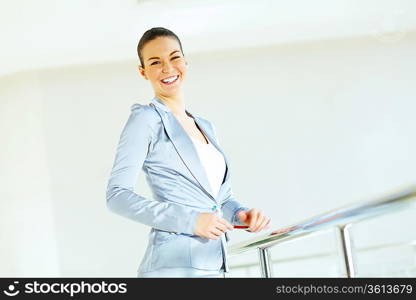 Portrait of happy smiling young businesswoman in office